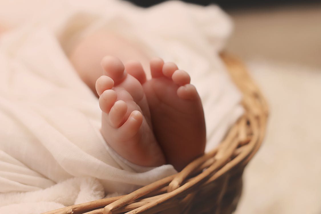 Free Baby's Feet on Brown Wicker Basket Stock Photo